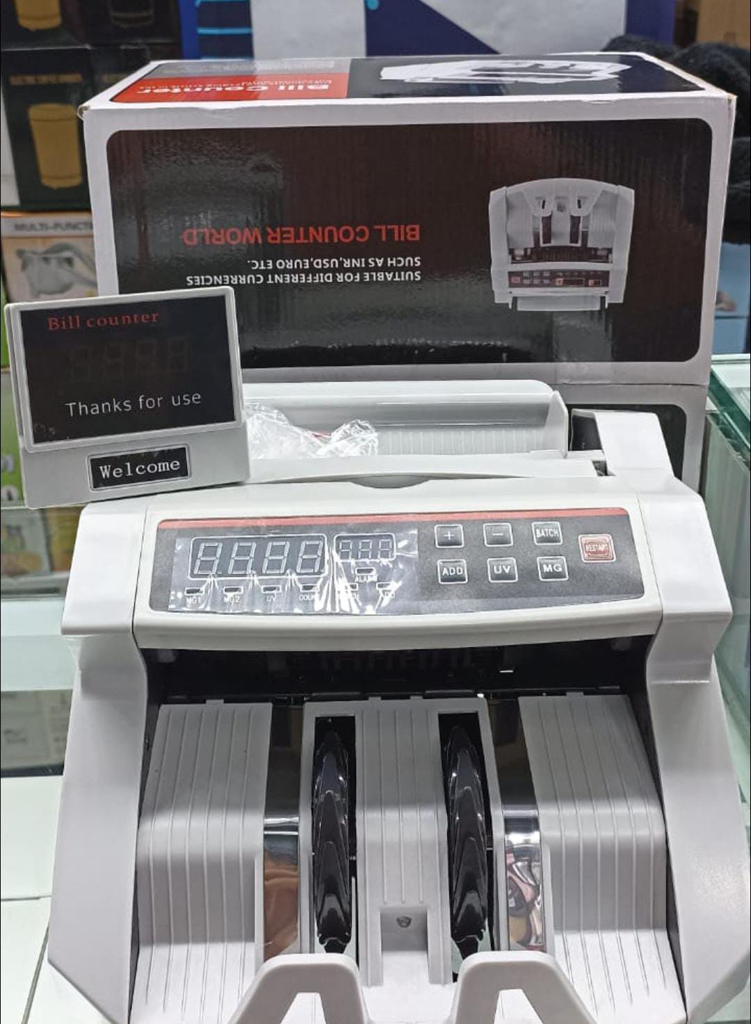 Máquina contadora de billetes blanca con bandeja de alimentación y pantalla frontal